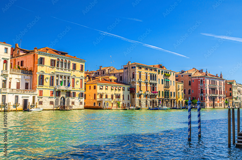 Grand Canal waterway with row of colorful multicolored palace buildings in Cannaregio sestiere Venice historical city centre, blue clear sky background, beautiful summer day, Veneto Region, Italy