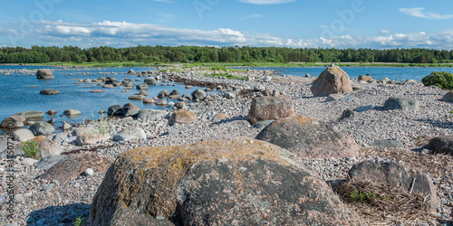 Wild rocky coastline of the Baltic sea in summer. View of the cape with large boulders in the foreground. Purekkari cape, Estonia. photo