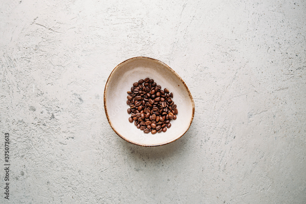 Autumn concept with coffee beans and yellow leaf on concrete background with copy space Autumn concept with coffee beans and yellow leaf on concrete background with copy space