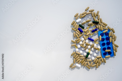 Flat lay of different pills and capsules are on the table from virus. Assorted pharmaceutical medicine pills, tablets and capsules. 