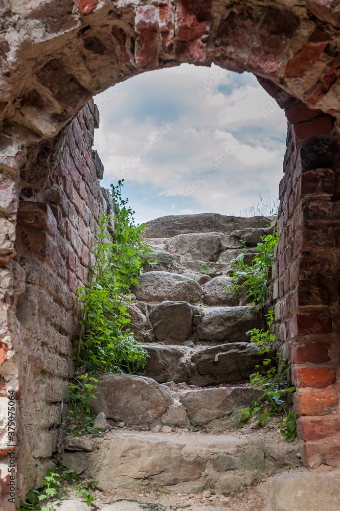 Underground stairs of European medieval ruins. Old stone stairs to exit of tunnel. Viljandi Order Castle, Estonia.