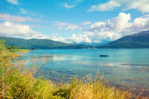 View of the fjord on a summer sunny day. Seashore with beautiful cloudy sky. Beautiful nature of Norway