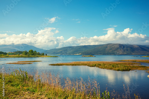 View of the fjord on a summer sunny day. Seashore with beautiful cloudy sky. Beautiful nature of Norway