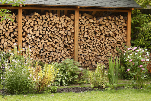 beautiful formal garden with flowers and fire wood storage