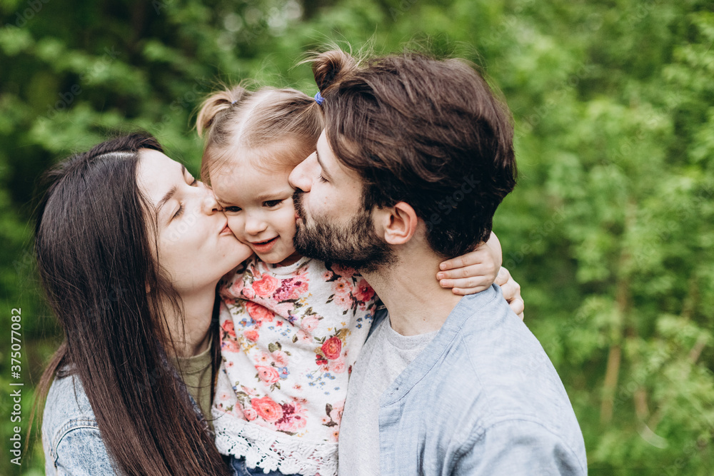 Happy stylish family: Photo of a young family enjoying a vacation in a park in a spring countryside Happy stylish family: Photo of a young family enjoying a vacation in a park in a spring countryside