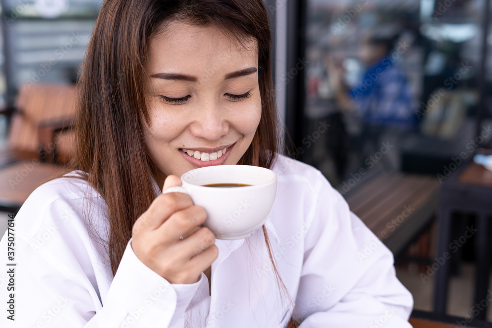 Beautiful Asian women drink coffee or tea in relaxation. Women are happy and enjoying in the coffee shop. Rest and relaxation concept Beautiful Asian women drink coffee or tea in relaxation. Women are happy and enjoying in the coffee shop. Rest and relaxation concept