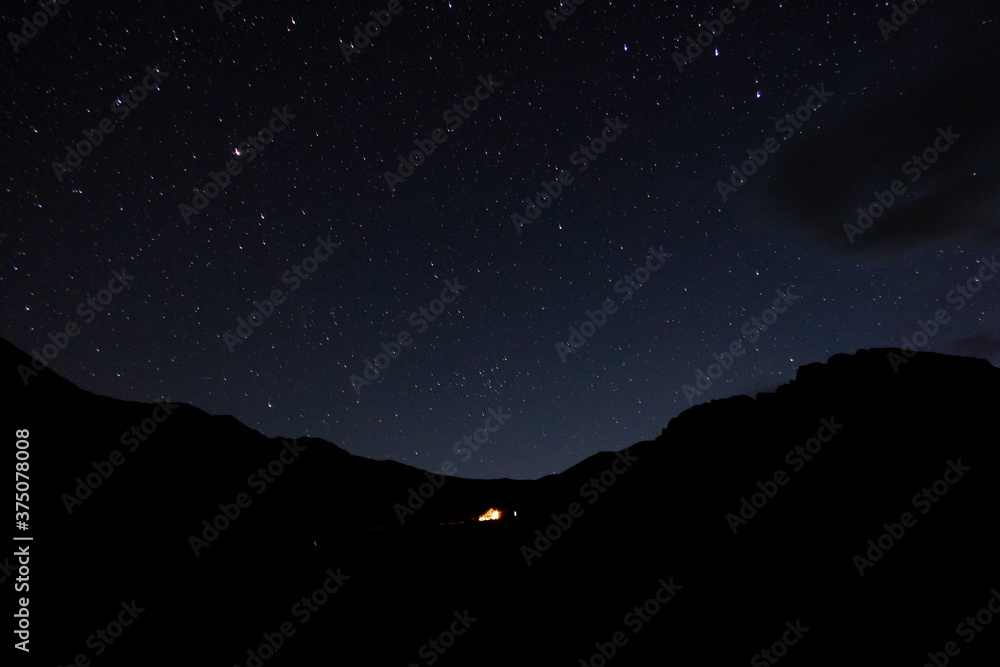 Starry sky in the mountains. Tourist tent in the mountains under the starry sky. Starry sky in the mountains. Tourist tent in the mountains under the starry sky.