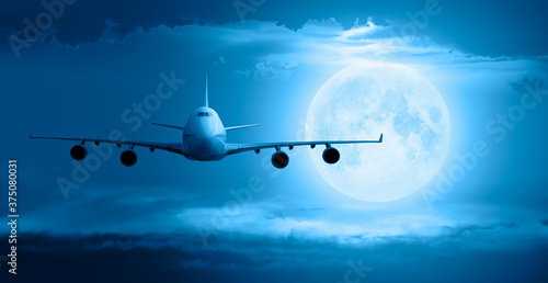 Passenger airplane in the sky, full moon at sunset in the background "Elements of this image furnished by NASA"