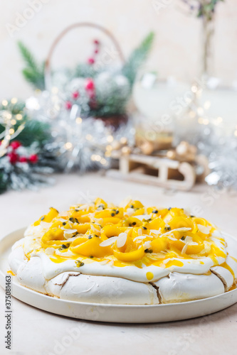 Meringue cake Pavlova with fresh mango and passion fruit and whipped cream on slate  stone or concrete background