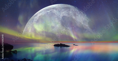 Fototapeta Naklejka Na Ścianę i Meble -  Northern lights (Aurora borealis) in the sky with super full moon - Tromso, 
 Norway 