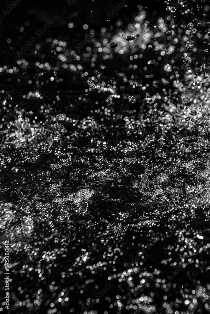 Drops of water splashing on a black background, bokeh focus. Drops of water splashing on a black background, bokeh focus.