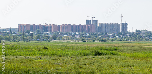 Summer landscape, city in the distance against the sky. © Prikhodko