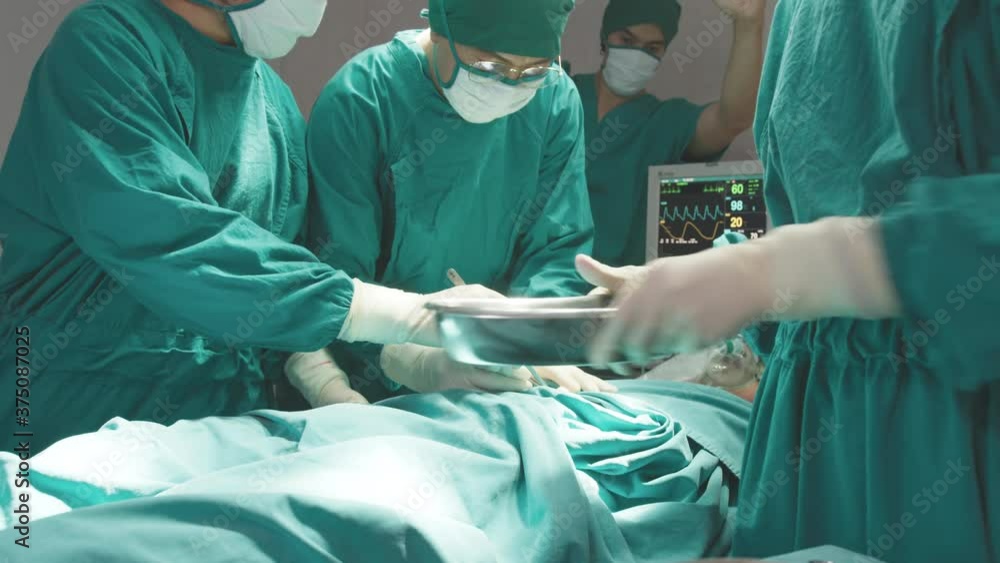 Emergency moment to help patient at operate room. Doctor, nurse and staff in surgeons holding medical instruments in hands, looking at patient and operating. Teamwork, Healthcare and medicare concept. Emergency moment to help patient at operate room. Doctor, nurse and staff in surgeons holding medical instruments in hands, looking at patient and operating. Teamwork, Healthcare and medicare concept.