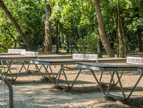 Worn out ping pong tables in Herestrau park, Bucharest.. Outdoor metal tables for tennis.