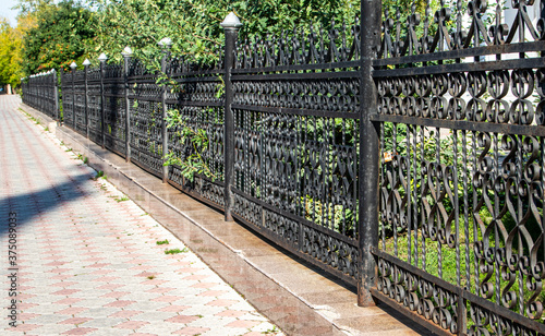 Forged metal fence along the city park.