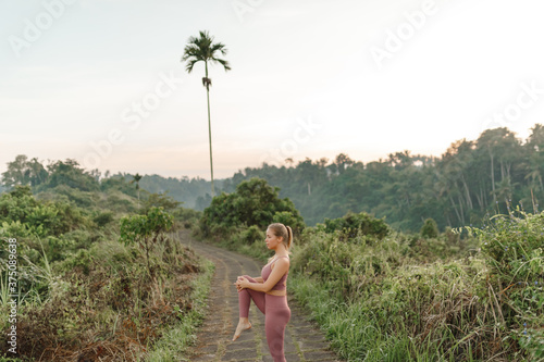 Young woman doing yoga in morning park. Concept of calm and meditation photo