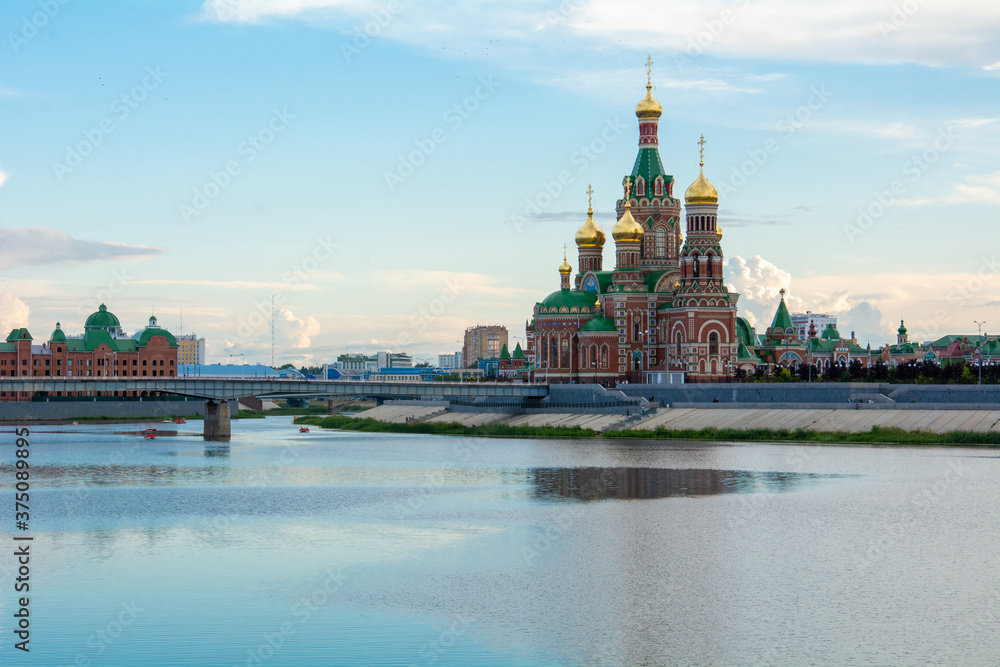Russia, Yoshkar-Ola, July 24, 2020, sunset, view from the embankment of the Kokshaga river to the bridge and the Kremlin, reflection in the water.