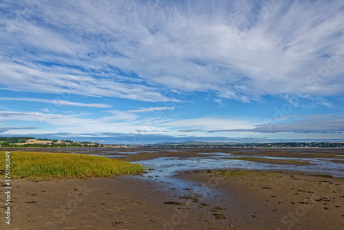 Looking back at Dundee and Tayport in the Tay Estuary at Low tide on a sunny day in August, with the large gently shelving sandy beach exposed.