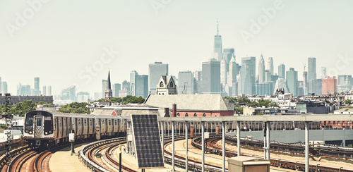 Obraz na płótnie New York subway train with Manhattan skyline in background, color toned picture, USA