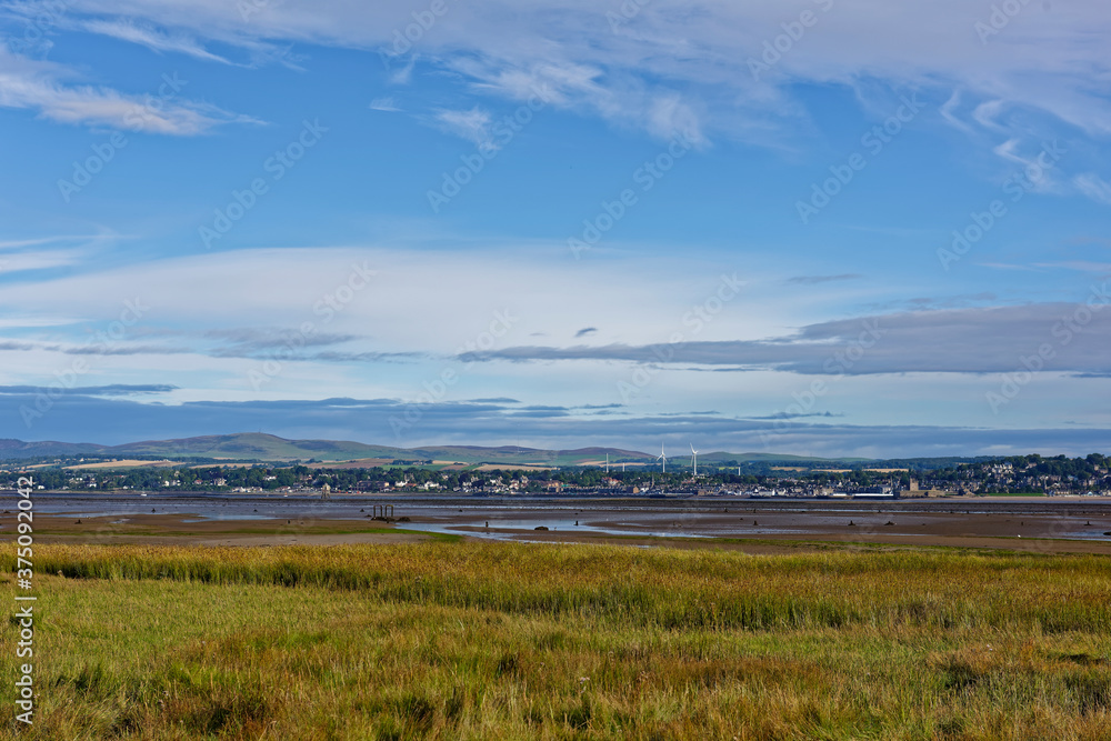 Low tide at the Tay estuary with the Reeds of Tay Heath exposed and the Town of Broughty Ferry in the distance across the Water.
