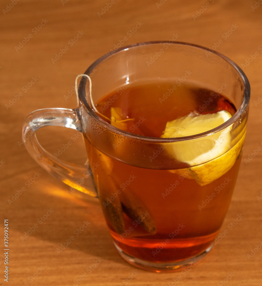 A transparent cup of tea with lemon on the table. A transparent cup of tea with lemon on the table.