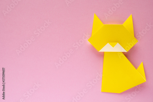 yellow origami cat on pink background