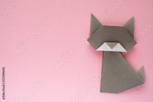 gray origami cat on pink background