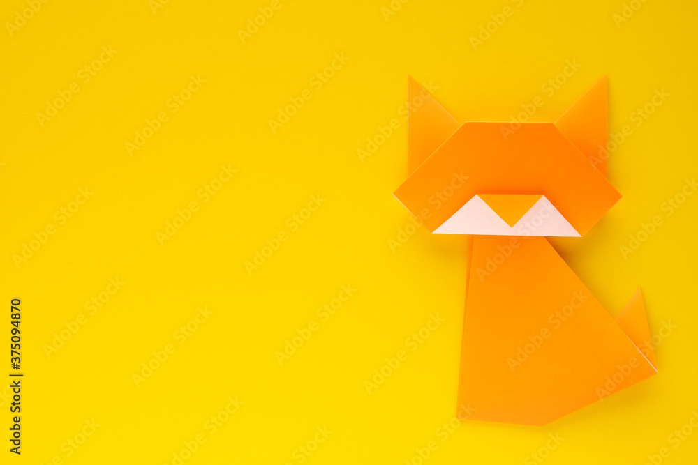 orange origami cat on yellow background orange origami cat on yellow background