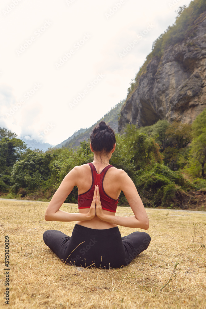 Yoga classes in nature. The concept of playing sports alone. Social exclusion. A woman does yoga in the mountains Yoga classes in nature. The concept of playing sports alone. Social exclusion. A woman does yoga in the mountains