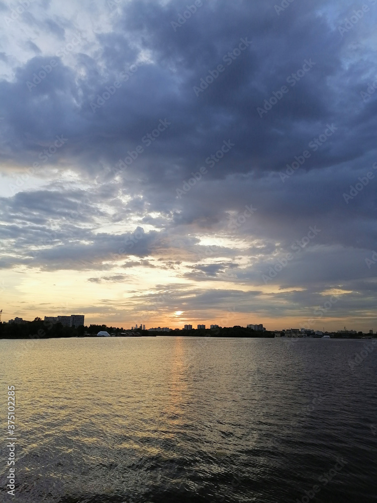 Fototapeta premium Beautiful sunset with the original clouds and the quiet water