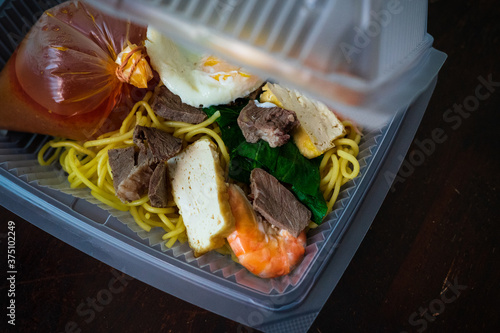 Mee Bandung Muar in a take out box, a Malaysia delicacy noodle originated from Muar District, Johore, Malaysia. The Noodle is a mixed of prawn, meat and seafood. Home delivery service. photo