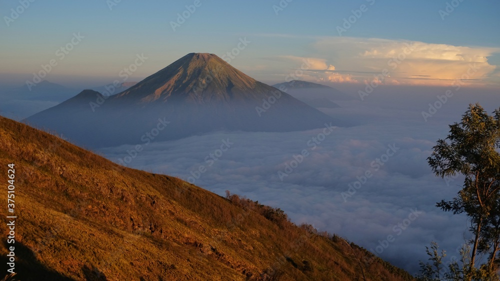 Mount Sindoro seen from the slopes of Mount Sumbing in the morning where thick clouds still lay covering the view down