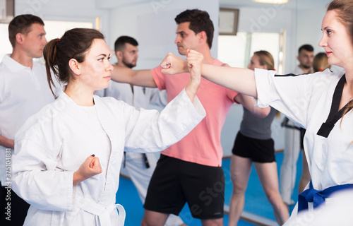 Adult trainees show their skills in training on karate in the room