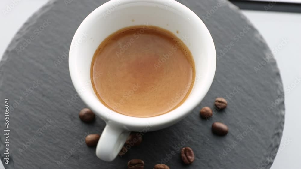 white cup with ristretto highly concentrated espresso coffee and beans