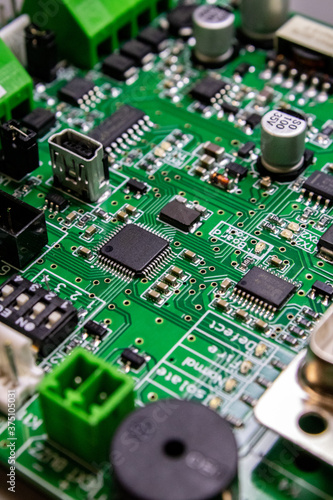 green circuitboard with microcontroller and lots of connectors