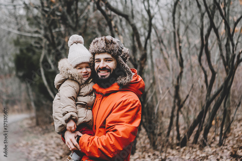Handsome young dad and his little sweet daughter have fun outdoors in winter. Happy family spending time together. Family concept.