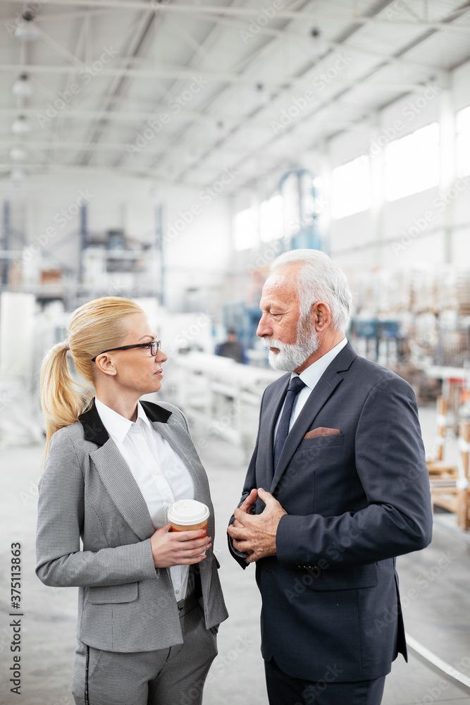 Obraz premium Man and woman discussing work. Colleagues working in factory.