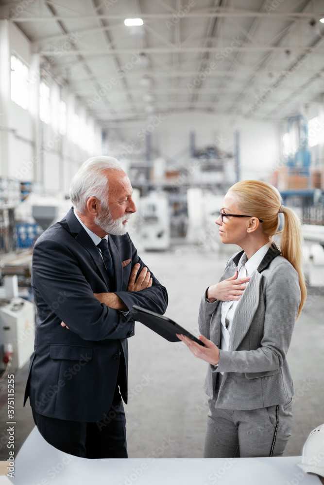 Man and woman discussing work. Colleagues working in factory. Man and woman discussing work. Colleagues working in factory.