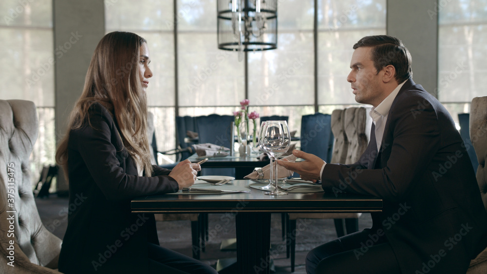 Business man and woman talking in restaurant. Businessman and businesswoman