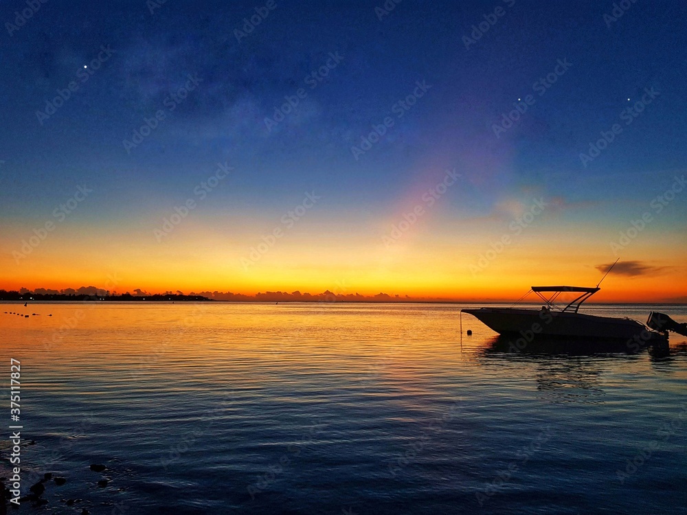 A boat in the sea during sunset time .
