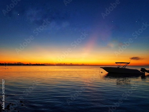 A boat in the sea during sunset time .