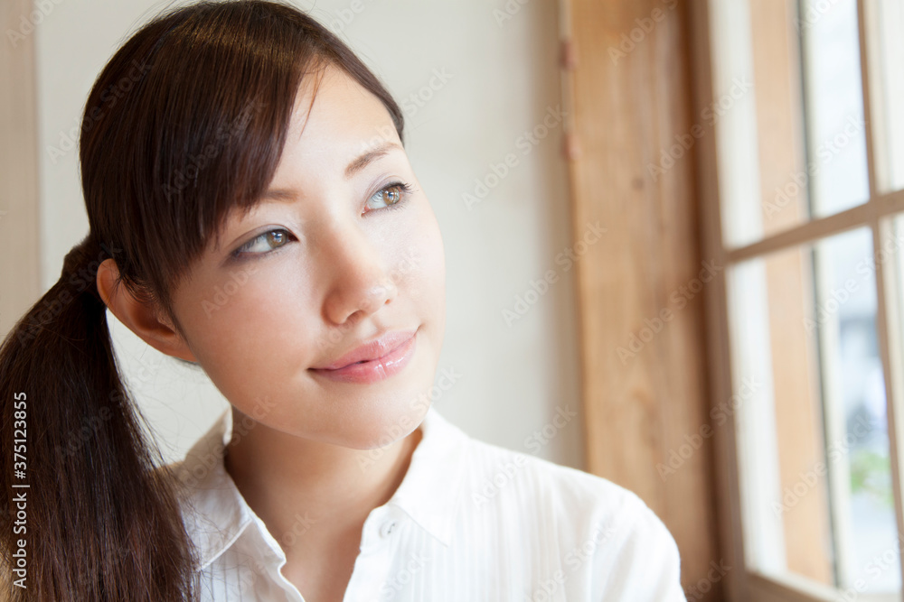 窓の外を眺める女性 窓の外を眺める女性