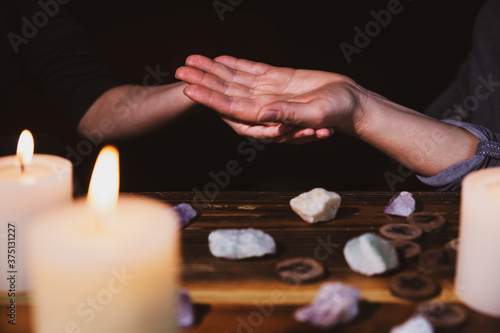 Photos palmistry or palm reading, fortuneteller holding a hand, healing stones and cand