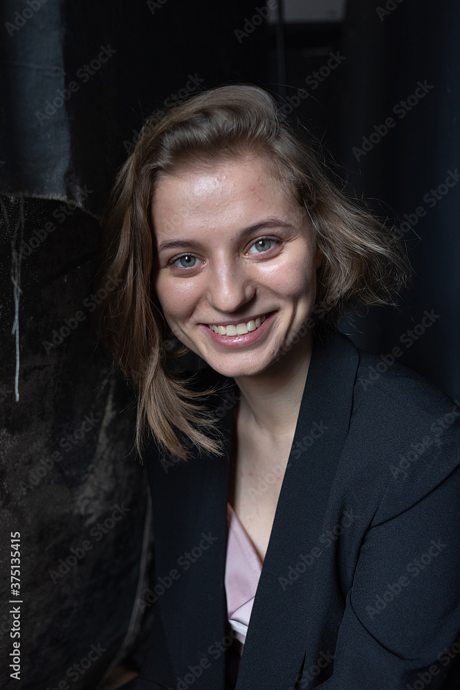 portrait of caucasian woman with short hair posing in suit jacket on black background, looking at camera. close up shot of pretty girl. attractive female poses at studio portrait of caucasian woman with short hair posing in suit jacket on black background, looking at camera. close up shot of pretty girl. attractive female poses at studio