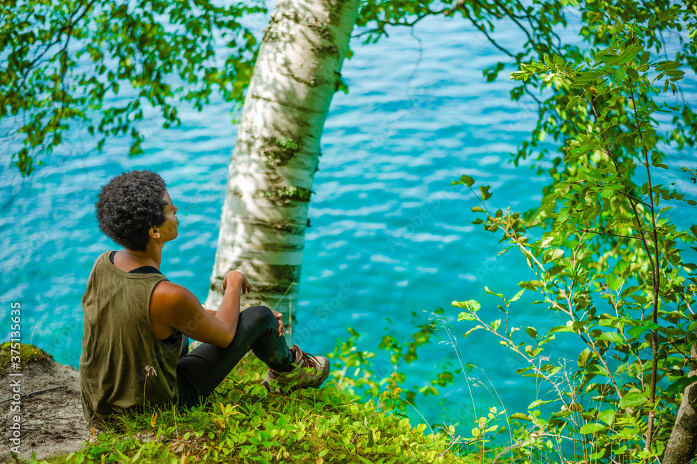© Abigail Marie - Woman sitting near blue water © Abigail Marie - Woman sitting near blue water