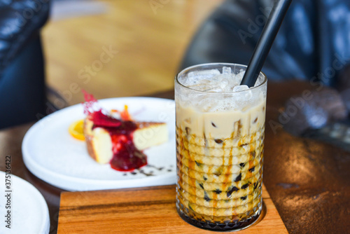 Bubble milk tea in glass on the wooden table with cake - Taiwan milk tea