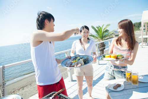 海辺でBBQをする男女