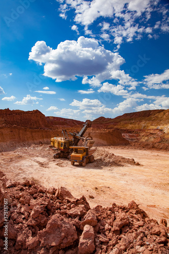 Aluminium ore mining. Bauxite clay Open-cut mining. Excavator loading ore to dump truck. Arkalyk, Kazakhstan.