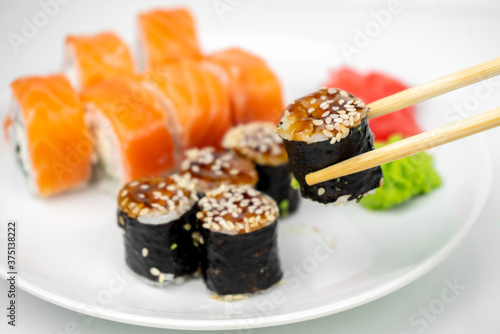 philadelphia maki rolls and eel unagi maki with soy sauce, pink ginger, wasabi on white background, asian food, japanese sushi set