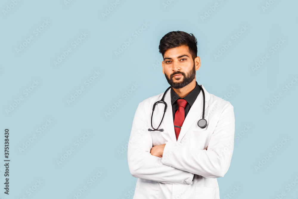 Cute Indian / Asian doctor wearing glasses with stethoscope, tie and white coat on light blue background. Cute Indian / Asian doctor wearing glasses with stethoscope, tie and white coat on light blue background.